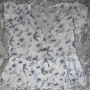 It’s a white blouse with elephants and palm trees